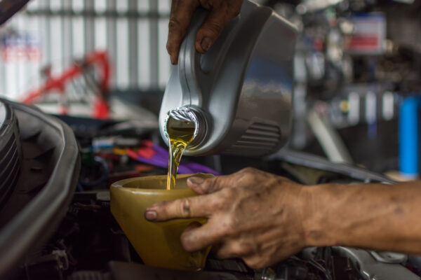 Mechanic filling oil into motorcycle